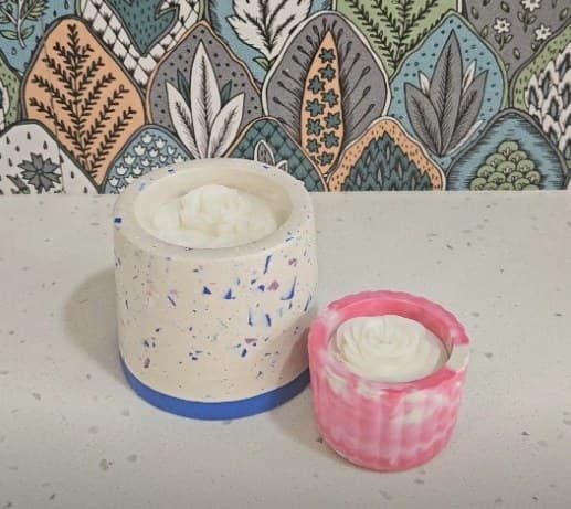 Two terrazzo-style jar candles in white and pink